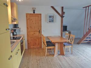 VipperowFerienhof direkt an der Mueritz SEE 10030的厨房配有木桌、椅子和门