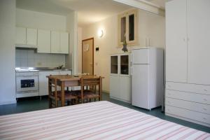 坎普码头Appartamenti Maricampo by HelloElba的厨房配有桌子和白色冰箱。