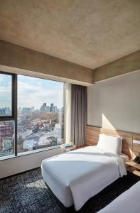 首尔HOTEL in 9 Gangnam的卧室设有一张白色大床和大窗户