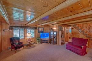 艾兰帕克Grandma's Cabin Yellowstone Vacation Home的客厅配有2把红色椅子和电视