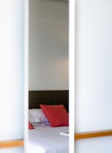 卡拉马塔Messinian Icon Hotel & Suites的一间卧室配有一张红色枕头的床