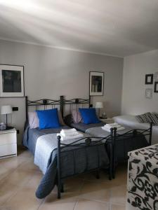 莫内利亚Villa Venino的一间卧室配有一张带蓝色枕头的床
