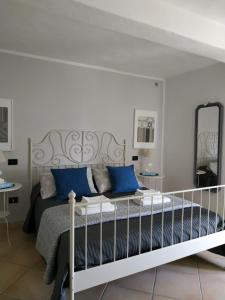 莫内利亚Villa Venino的一间卧室配有一张带蓝色枕头和镜子的床