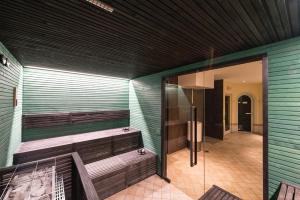 加尔达湖滨自由大酒店的一个带木凳和玻璃门的桑拿浴室