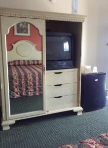 新奥尔良新奥尔良酒店的一间卧室配有一张床,并在橱柜里配有电视