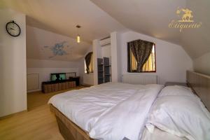 德瓦Villa Etiquette的卧室配有一张白色大床和时钟
