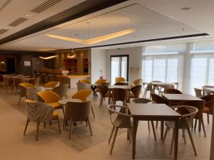滨海迪沃Résidence Services Seniors Domitys - Les Safrans的用餐室设有桌椅和窗户。