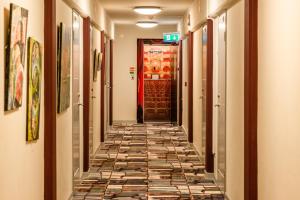 马尔默提特豪特莱特酒店的走廊设有瓷砖地板和红色门