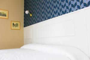 那不勒斯Don Raffaele Resort的卧室配有白色的床和蓝色壁纸