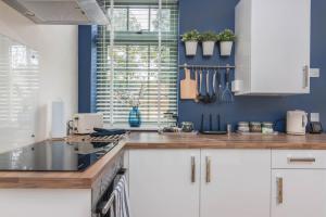 拉特沃思Rainbow House - Entire Place的厨房配有白色橱柜和蓝色的墙壁
