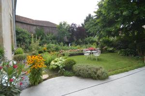 图勒Chambre d'hôtes à TOUL centre ville avec parking privé的花园配有桌椅和鲜花