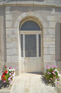 图勒Chambre d'hôtes à TOUL centre ville avec parking privé的石头建筑中一扇门,两朵花