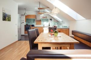 毛特恩Weingut Jakob`s Ruhezeit的厨房以及带木桌和椅子的用餐室。