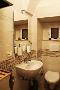 普蒂尼亚诺B&B La Campanella的一间带水槽、卫生间和镜子的浴室