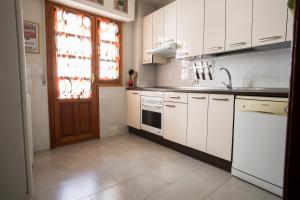 阿维拉VUT夫鲁塔广场公寓的厨房配有白色橱柜、水槽和窗户。