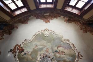 科莫Villa Platamone的墙上的天花板上画着一幅画,墙上装着窗户