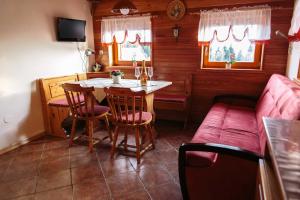 博希尼Holiday house Pokrovec - Bohinj的一间带桌子和沙发的小餐厅