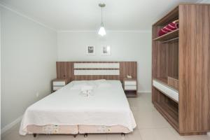 格拉瓦塔尔城堡酒店的一间卧室配有一张白色大床和木柜