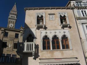 皮兰Benecanka Casa Veneziana Piran的一座建筑,后方有钟楼