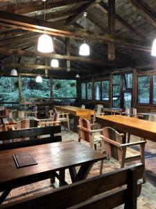 阿雷富Cabana Zimbru Transfagarasan的餐厅设有木桌和椅子及灯