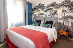 阿维尼翁科利雅得阿维尼翁万国宫大殿酒店的一间卧室配有一张带红色毯子的大床