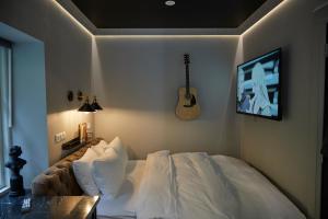 阿克雷里Hotel Akureyri Dynheimar的卧室配有一张床,墙上配有吉他