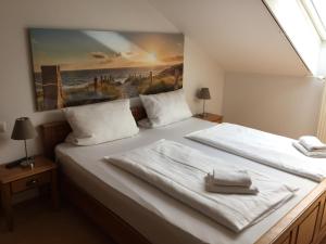 鲁斯特Gästehaus am Wasserpark的一间卧室设有两张床,墙上挂着一幅画