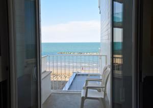 佩萨罗亚历山大博物馆宫酒店的享有海滩美景的阳台和椅子