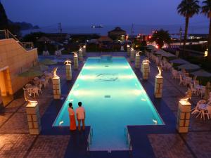 西伊豆町Nishiizu Crystal View Hotel的两人晚上站在游泳池旁