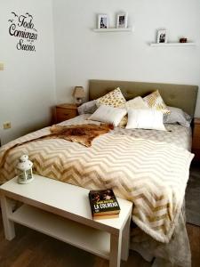 San LorenzoLa casa de la abuela的一间卧室配有一张床和一张桌子及一本书
