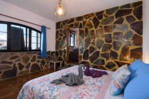 蒂纳霍Buda的一间卧室设有石墙和一张床