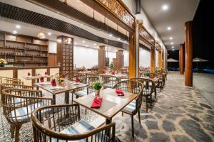 枚州县Mai Chau Mountain View Resort的一间在房间内配有桌椅的餐厅