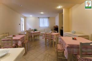 梅萨涅加蒂诺Il号德勒塞特住宿加早餐旅馆的用餐室配有桌椅和粉红色的桌布