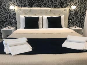 斯培西亚Alba rooms的一张白色大床,配有黑白枕头