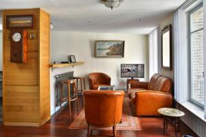 翁弗勒尔穆加多尔公寓的一间设有皮椅和壁炉的等候室