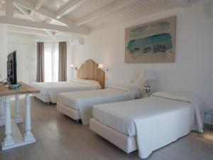 斯廷蒂诺阿西纳拉公园酒店的白色的客房设有三张床和一张桌子