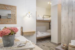 依诺罗达Meltemi luxury apartments的配有床、镜子和鲜花桌的房间