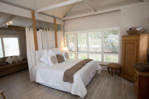 古尔瓦Boathouse - Birks River Retreat的卧室设有白色大床和窗户。