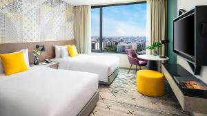 曼谷Avani Sukhumvit Bangkok Hotel的酒店客房设有两张床和大窗户。