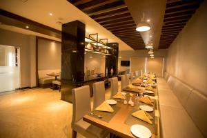 钦奈S Hotels Chennai的长长的用餐室配有长桌子和椅子
