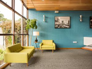 霍巴特滨河汽车旅馆别墅酒店的客厅设有黄色椅子和蓝色的墙壁