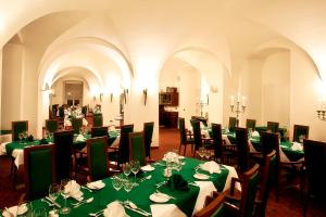 施瓦岑费尔德施彻沃赞菲尔德施洛斯酒店的用餐室配有绿色的桌椅