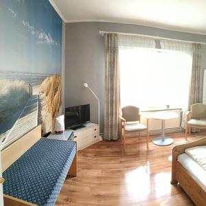 文斯托夫施泰因胡德亚特兰蒂斯旅馆的一间卧室配有一张床和一张沙发桌子