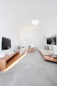 梅加洛克里阿尼莫里亚别墅酒店的客厅配有白色家具和平面电视