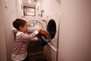 东京日本桥阿克萨斯公寓式酒店的一名男孩正在装洗衣机
