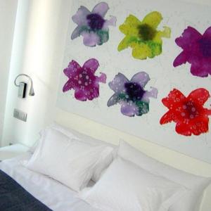 布尔戈斯艾库阿乐旅馆的床上方墙上的花画