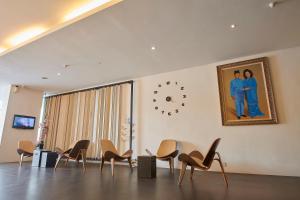 阿罗士打莱维拉治商务酒店（班达尔巴鲁美贡） 的一间设有椅子和墙上的时钟的房间