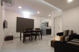 班加罗尔Livi Suites - Premium 1 BHK Serviced Apartments的客厅配有桌椅和电视。