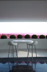 雅典塞米勒米斯酒店的窗前的一张白桌子和两张凳子
