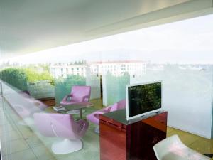 雅典塞米勒米斯酒店的客厅配有粉红色的椅子和电视
